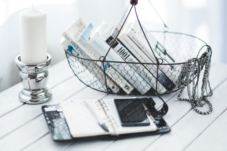 Basket of books on table with open personal calendar book