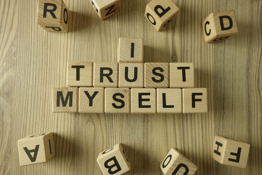 wooden cubes with letters on them, spelling out "I Trust Myself"