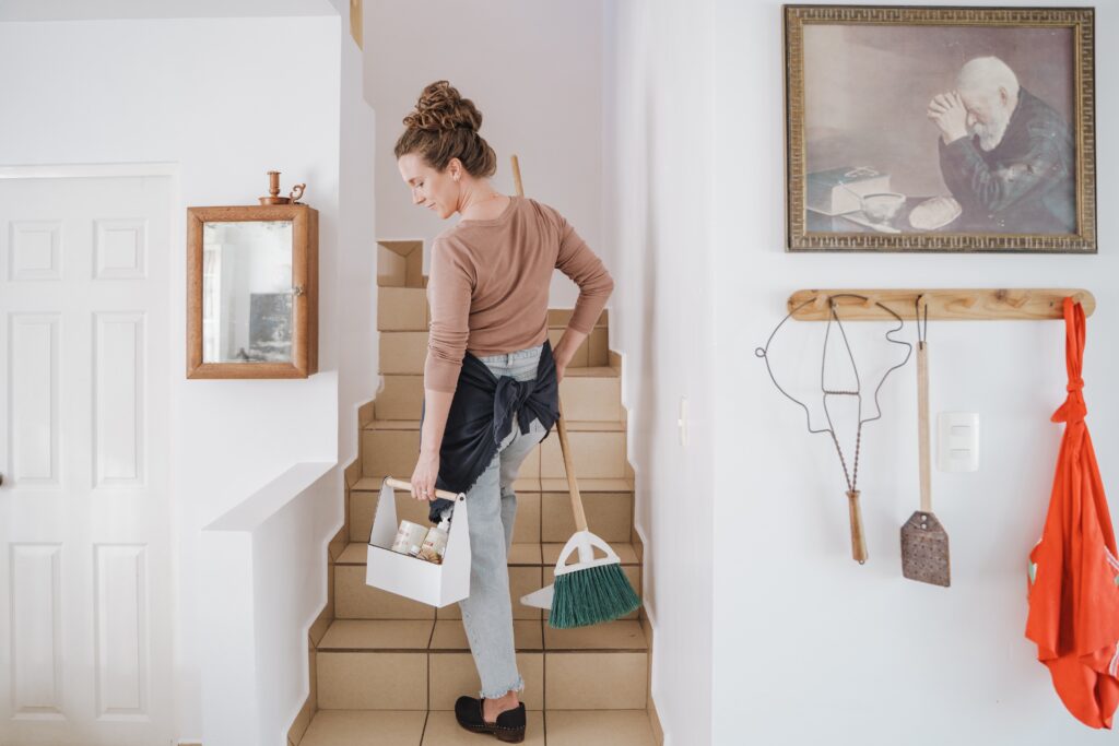 woman walking up stairs with cleaning equipment 