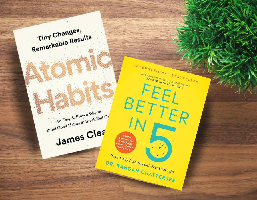 books atomic habits and feel better in five on a desk with a plant