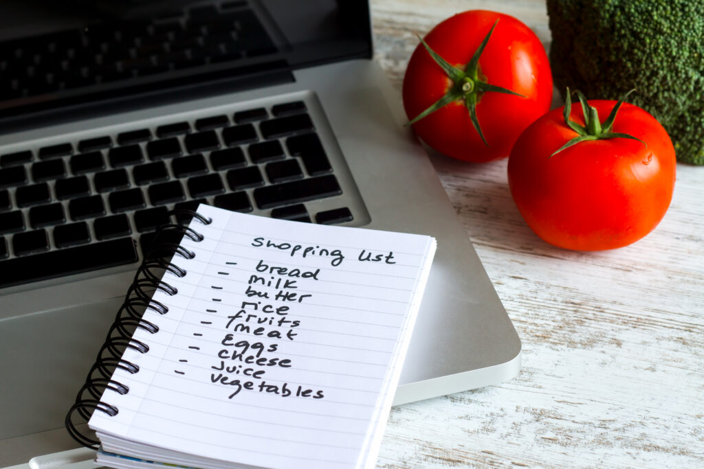 computer with shopping list and 2 tomatoes