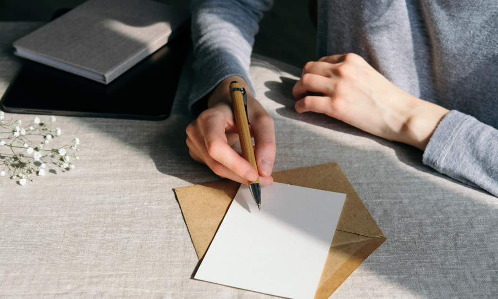 person about to write a message on a blank white card