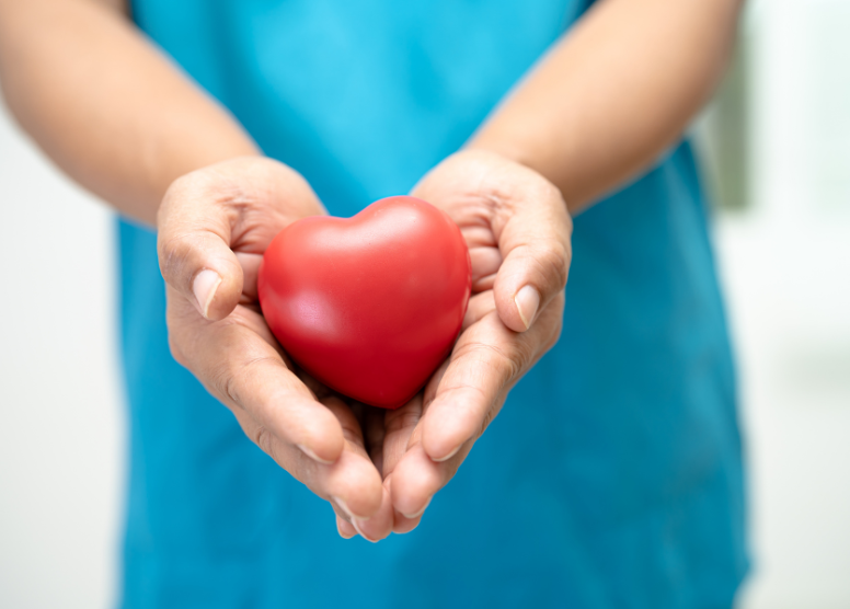 person's hands holding a red item shaped like a heart