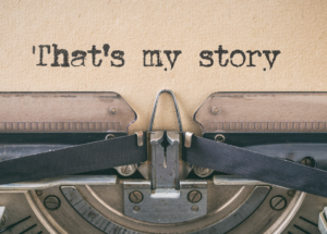 close-up of a piece of paper in a typewriter. "That's my story" is typed on the paper