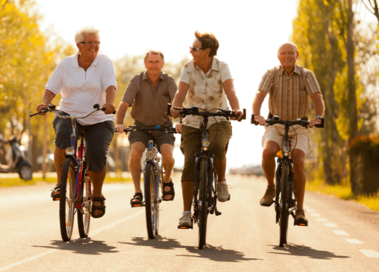 four older men riding bicycles side by side