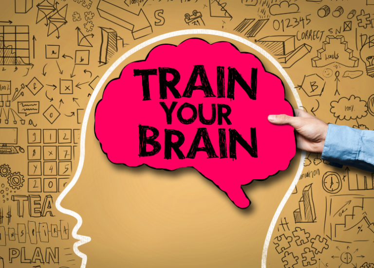 Image of drawn silhouette of a head (side view) with a person's hand holding a red, brain-shaped sign with the words "Train your brain" written on it. Background is equations, puzzles, graphs, etc written in black pen