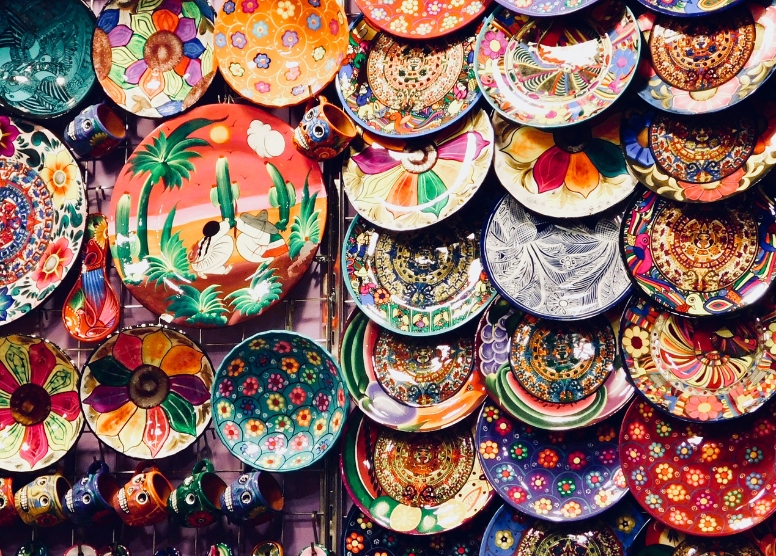 colorful handpainted plates and bowls hanging on a wall