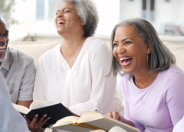 group of people reading books and laughing together