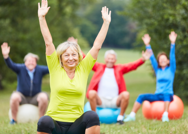 seniors sitting on exercise balls exercising outdoors