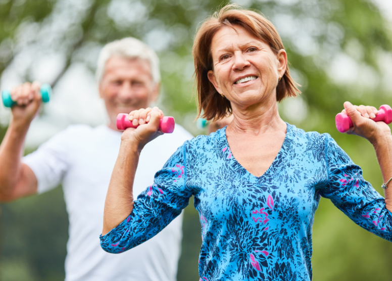 senior man and woman exercising with small weights