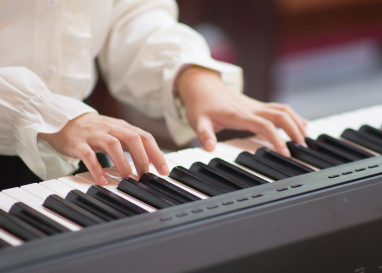 close of of a person playing a keyboard (instrument)