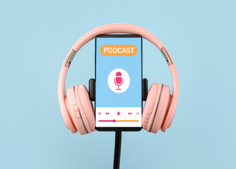 smartphone in a holder with pink over-ear headphones resting on top of it. On the screen: word "Podcast", microphone icon, buttons -- pause, play, fast forward, rewind