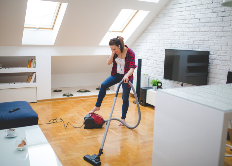 woman listening to a podcast while she vacuums