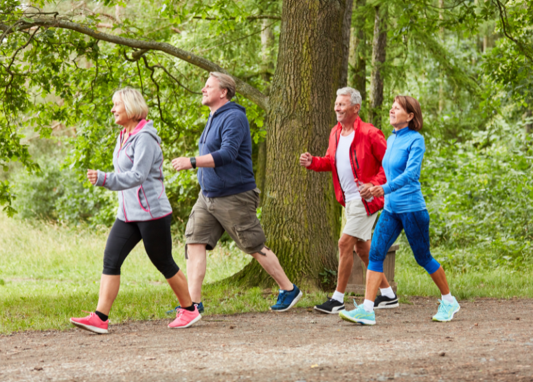 group of seniors walking on a wooded path