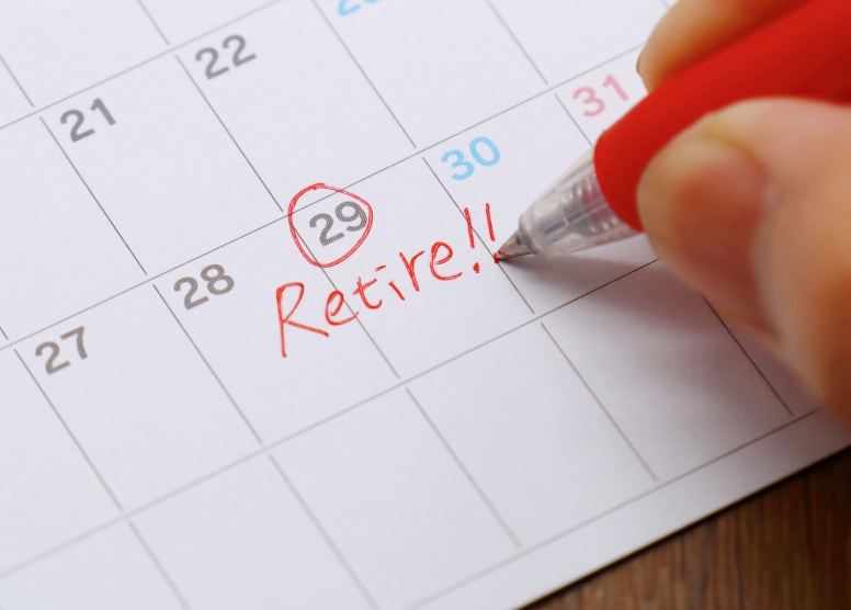 person writing the word "retire!!" on a calendar